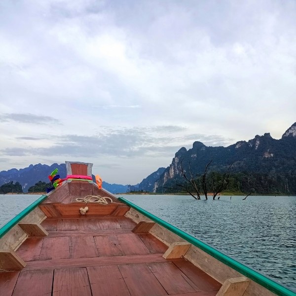 Your Front-Row Seat to Adventure Long-Tail Boat POV Facing Khao Sok's Dramatic Limestone Cliffs